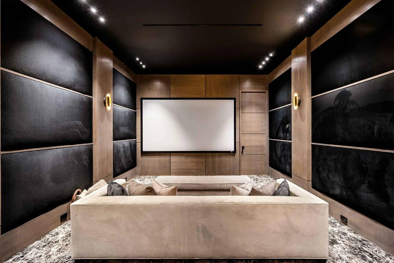 Salle de cinéma privée avec boiseries sombres, écran grand format et banquette sur mesure, Pays Basque